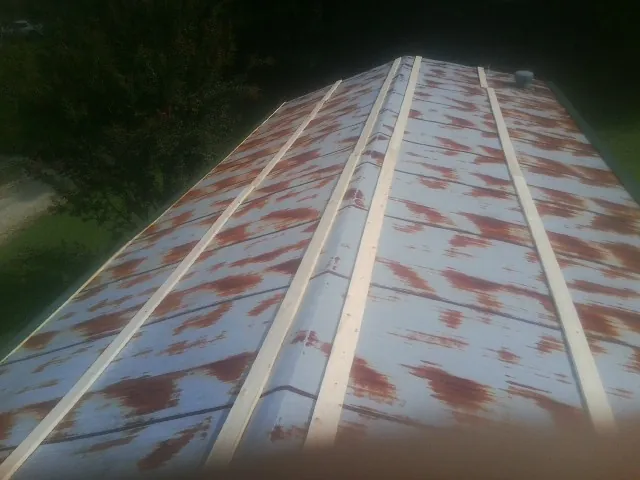 Rusted metal roof panels with new wood purlins before replacement — Storm Damage Roof Repair in Logandale by Roofing Brothers