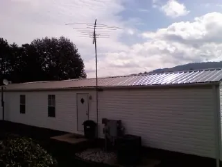 New metal roof on a single wide mobile home with a TV antenna in Logandale